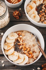 healthy breakfast bowl. oatmeal with banana, walnuts, chia seeds and honey