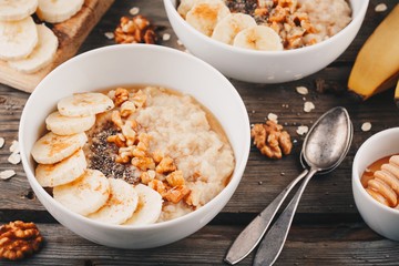 healthy breakfast bowl. oatmeal with banana, walnuts, chia seeds and honey