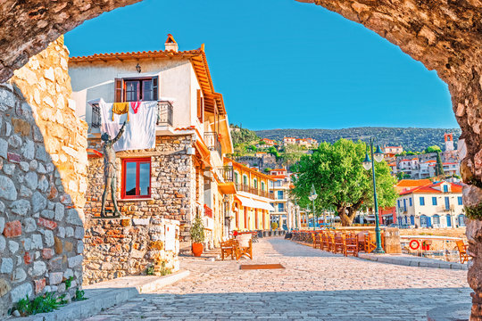 View on old medieval Greek city Nafpfktos Though arch in ancient medieval castle wall, popular and famous travel landmark. Nafpaktos is popular European travel destination. Old houses on embankment. 