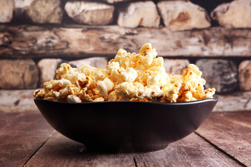 Salt popcorn or sweet popcorn in bowl on the wooden table