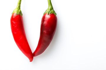 Two red chilli peppers touching each other form a 