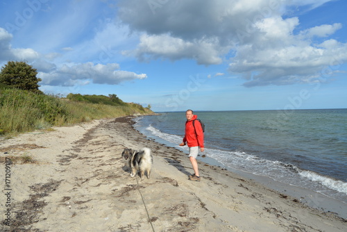 "Mann mit Hund am Strand Urlaub am Meer" Stock photo and royaltyfree