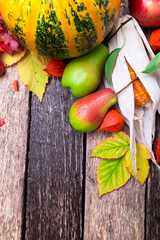 Thanksgiving background with autumn fruits and gourds on a rustic wooden table. Autumn harvest. Top view. Copy space. Thanksgiving frame