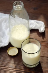 Tasty rustic milk and glass on wooden background 