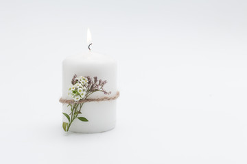 vela blanca encendida con flores