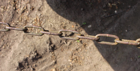 Rusty metal chain on ground