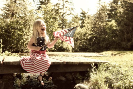 Happy little girl with American flag at Independence day