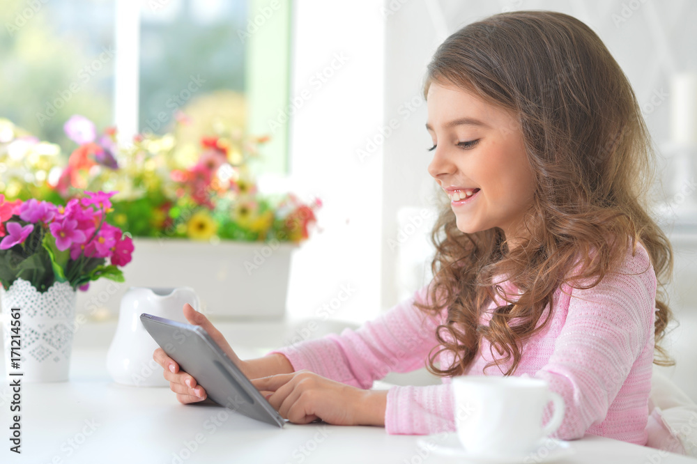 Wall mural beautiful little girl with tablet pc