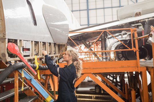 Female aircraft maintenance engineer working over an aircraft