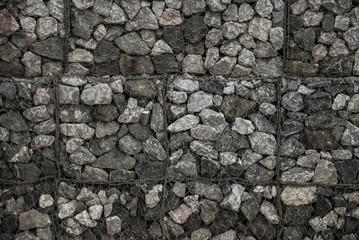 Texture of stones and rock in the wire net background.