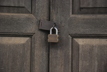 Master key padlock on wooden door background,