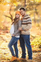 Fototapeta premium Young happy family have fun and walking in the autumn park. Pregnant woman with husband 