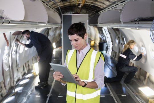 Female aircraft maintenance engineer using digital tablet in an