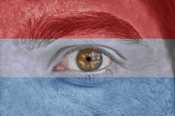 Human face and eye painted with flag of Luxembourg