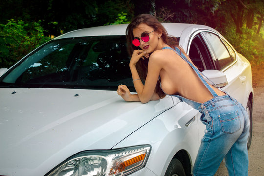 young hot brunette leaned on the car
