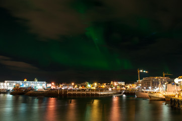 Fototapeta na wymiar Aurora borealis in Reykjavik harbor in Iceland