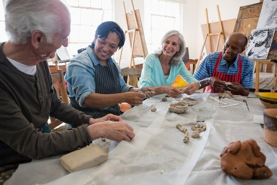 Smiling Senior Friends Making Clay Products