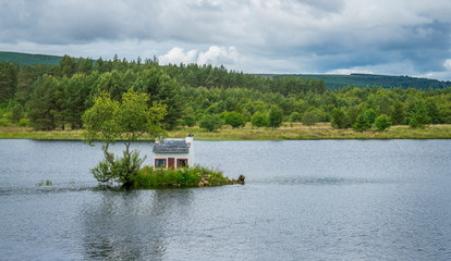 Obraz premium The Wee Hoose, a small house built in Loch Shin, near Lairg in the Scottish North West Highlands.