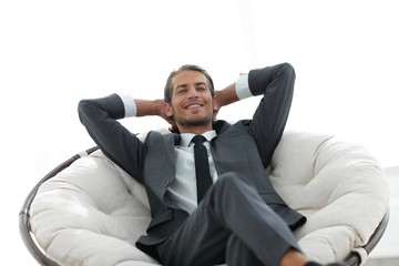successful businessman sitting in a large comfortable chair