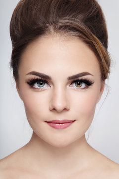 Portrait of young beautiful stylish smiling girl with hair bun and winged eyes make-up