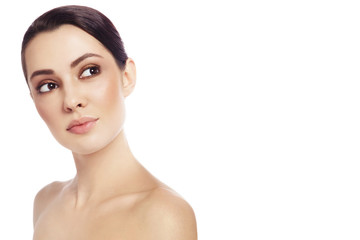 Young beautiful woman with clean make-up looking upwards over white background, copy space
