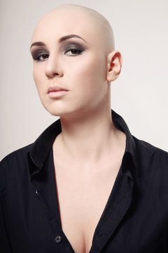 Portrait of young skinhead woman with smoky eyes make-up