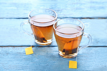 Cup of tea with teabag on blue wooden table