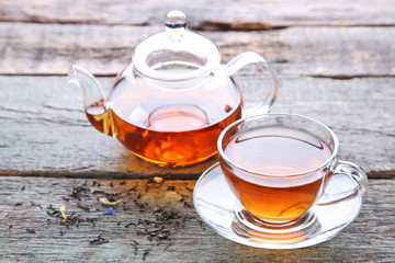 Cup of tea with teapot on grey wooden table