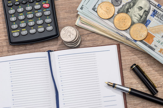empty notepad, pen, doolar and coin on desk