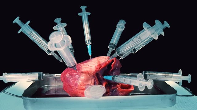 heart pricked with syringe on black background