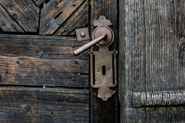 Old Door Handle. Foreground of old wooden door with iron handle..