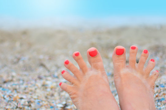 Woman toes with pedicure in a funny trip on a beach