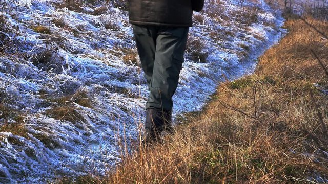 Man goes on the border of snow and grass - (4K)