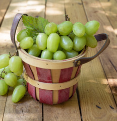 Basket of Grapes on a Rustic Wooden Surface