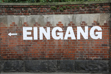 text EINGANG on the brick wall which means EXIT in german