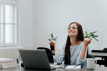 Beautiful woman at the office celebrating her success