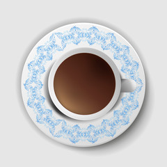 A cup of coffee with a decorative saucer