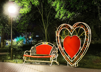 Beautiful red Romantic Love Bench in Pokrov city at autumn night. Ukraine
