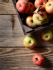 Box with ripe apples on wooden background