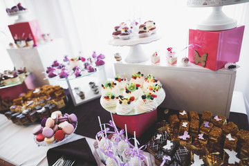 Delicious sweets on wedding candy buffet with desserts, cupcakes