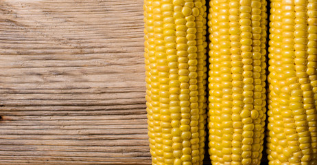 Some corn cobs macro on wooden background.