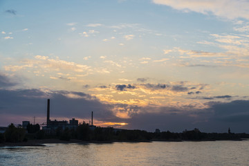 Obraz premium Factories along the Rhine river at sunset in Germany