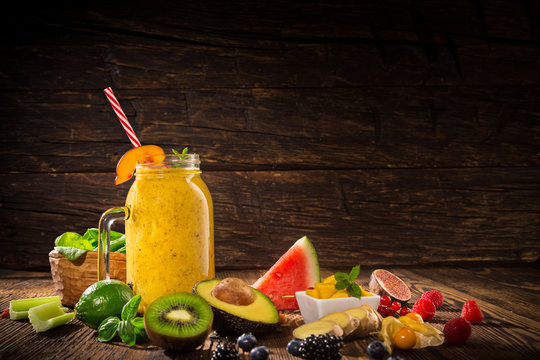 Healthy fresh smoothies with ingredients on old wooden table.
