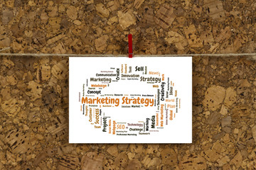 Marketing strategy word cloud on business card pinned up on cork board