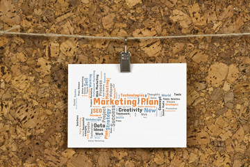 Marketing plan word cloud on business card pinned up on cork board