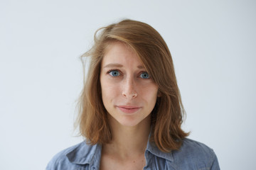Obraz premium Portrait of sad unhappy European girl having problem, looking with worried expression on her face. Beautiful blue-eyed female staring at camera with sorrow or concern while experiencing hard times