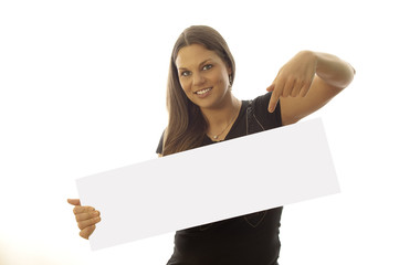 junge brünette Frau zeigt auf ein weisses Schild 