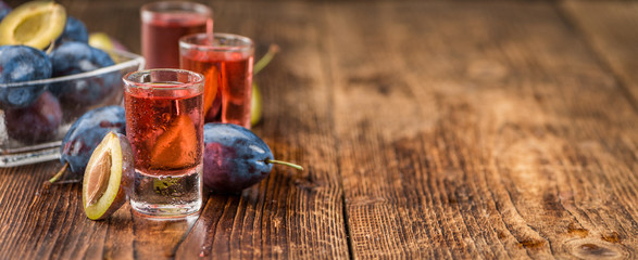 Fresh made Plum Liqueur on a rustic background