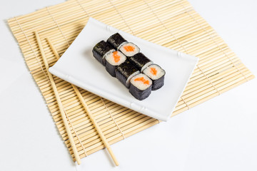 Sushi roll on plate and rolling mat