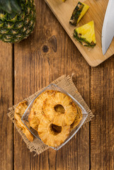Wooden table with Dried Pineapple Rings, selective focus